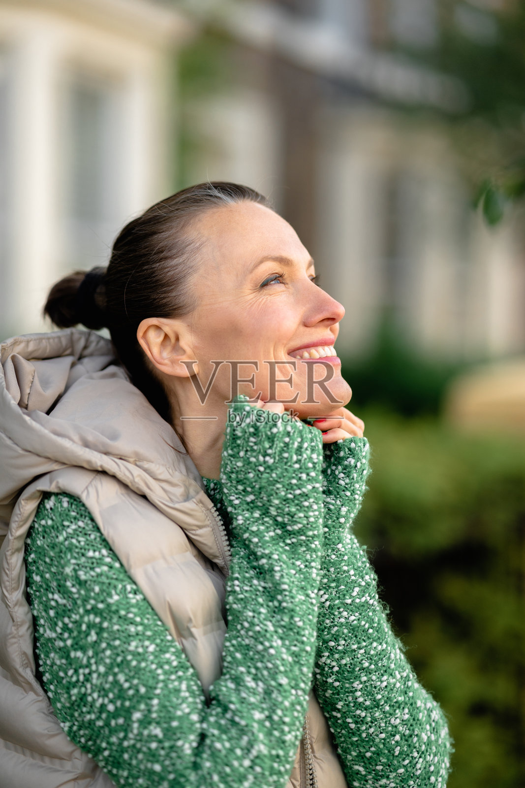 城市里穿着绿色毛衣的年轻女子的肖像照片摄影图片