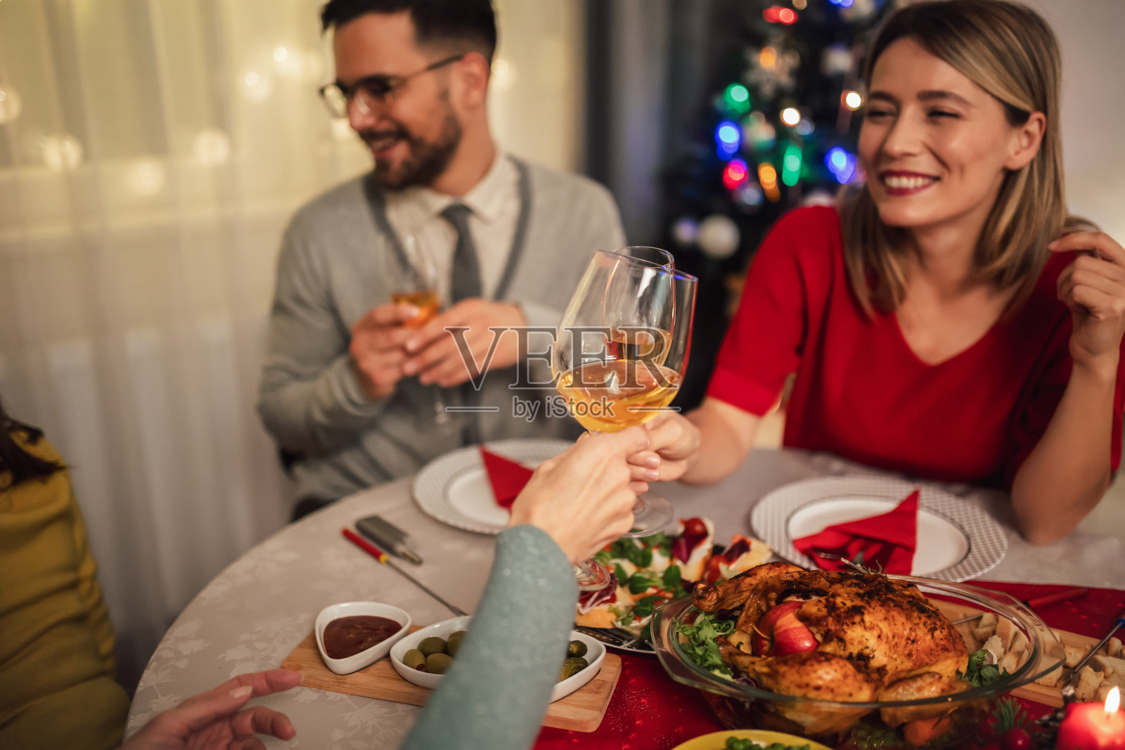 一对夫妇在晚宴上围坐在餐桌旁，边喝酒边笑照片摄影图片