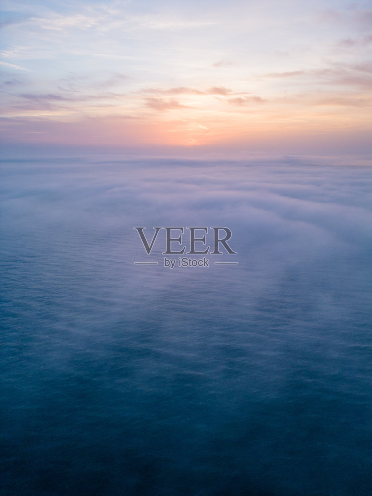 鸟瞰图，日出的海面上笼罩着晨雾和早晨的阳光照片摄影图片