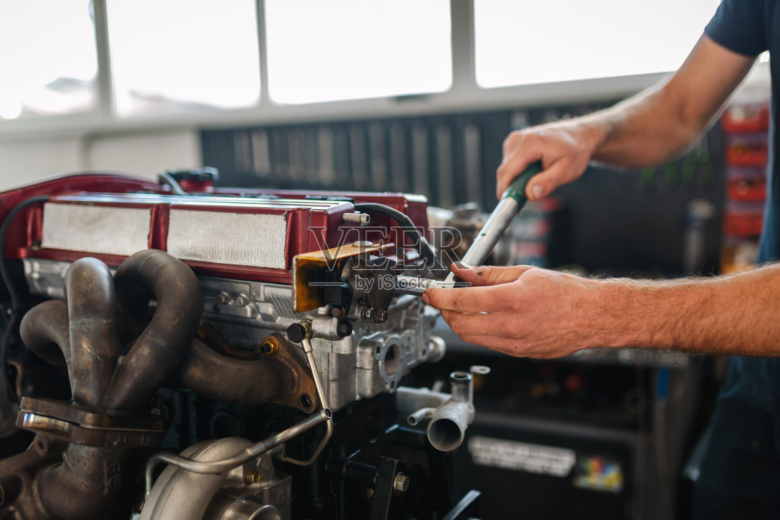 年轻的汽车修理工正在修理汽车发动机照片摄影图片
