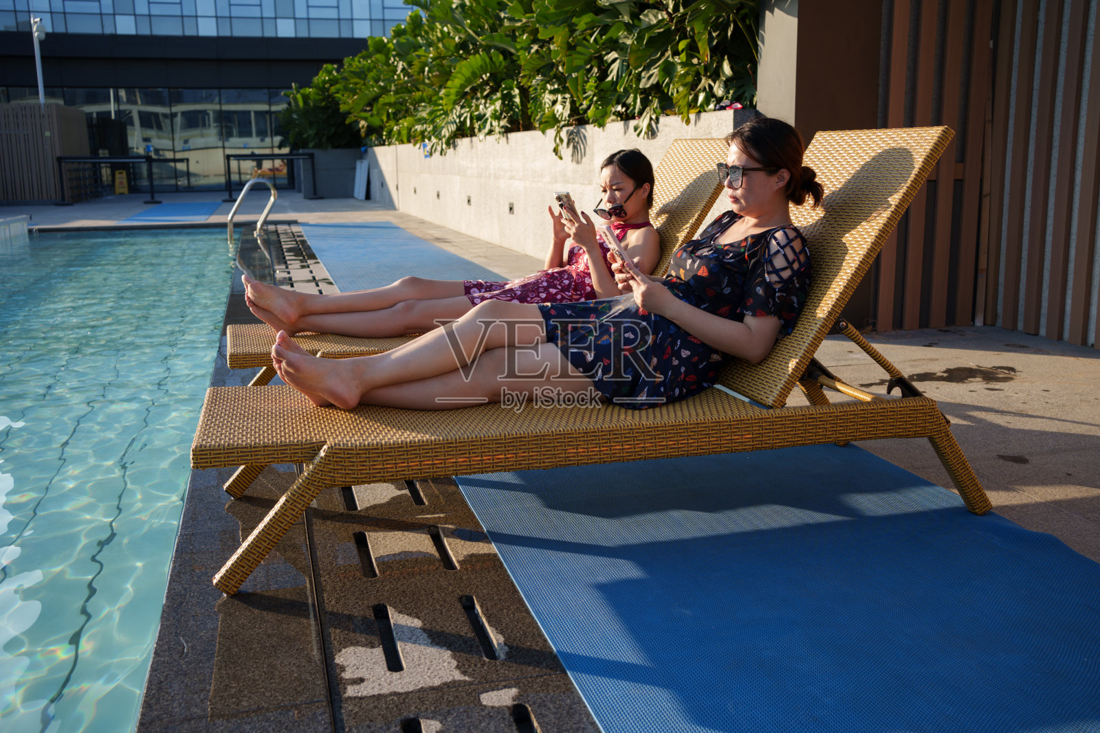 在泳池边晒太阳的女人照片摄影图片