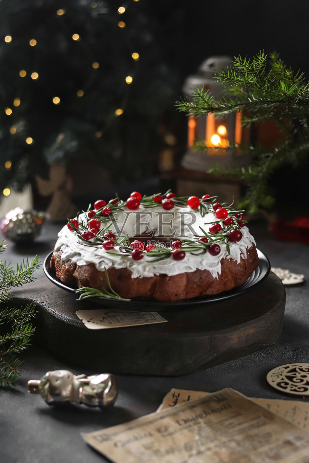 用蔓越莓、迷迭香和糖霜装饰的传统圣诞巧克力蛋糕。照片摄影图片