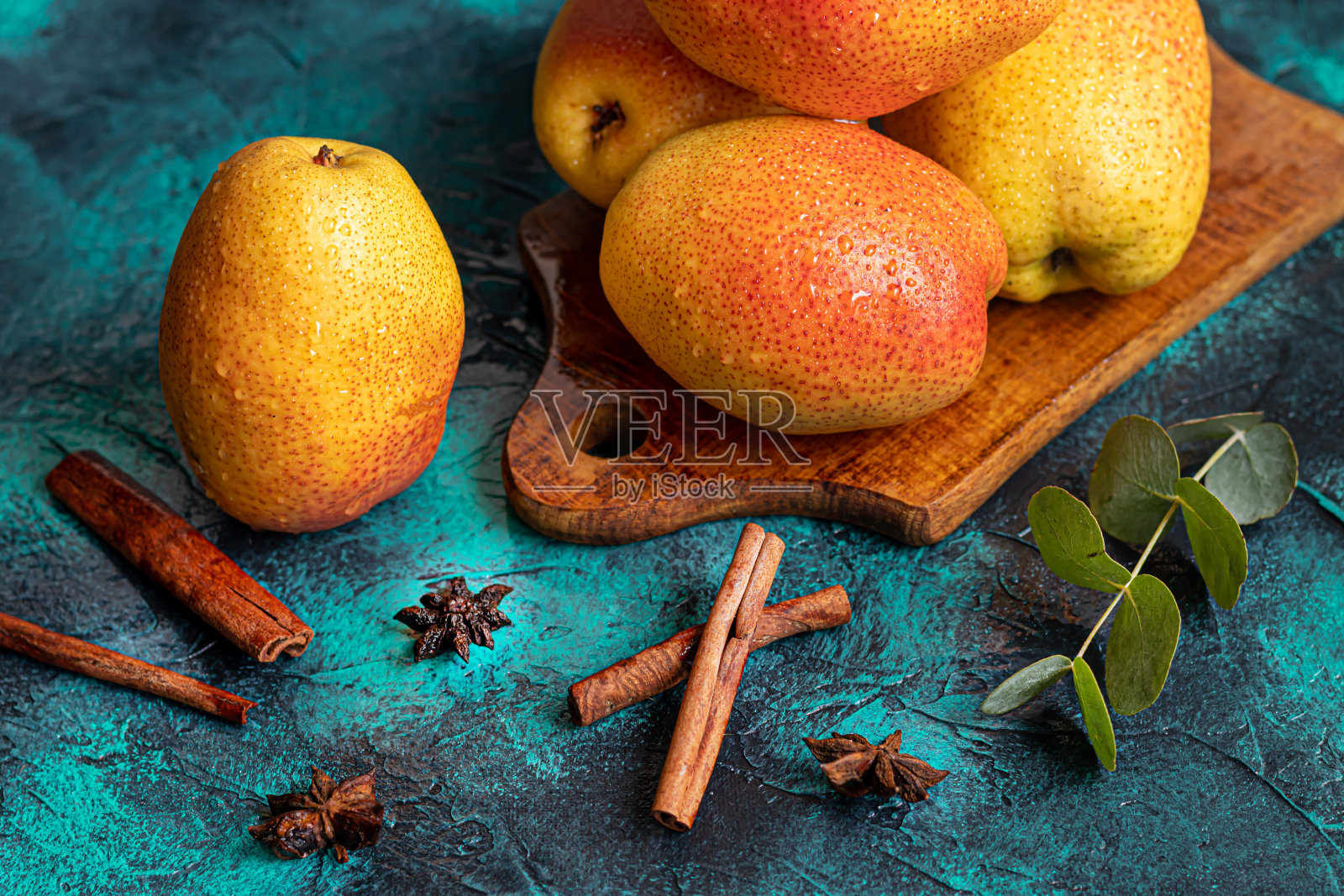 深色背景上的梨。新鲜、成熟的水果放在蓝色的盘子和盒子里。健康饮食。照片摄影图片