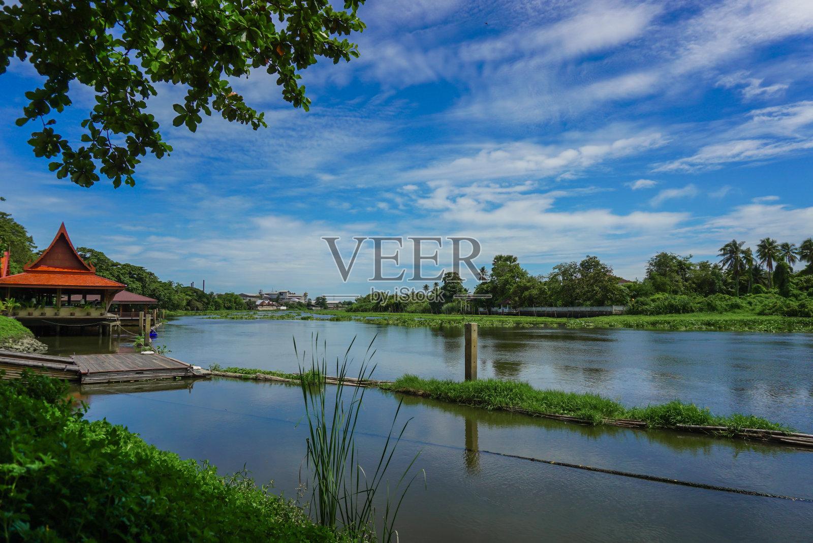 河上一个古老的木码头。云的黎明黄昏天空的广阔视野。泰国一条河上的漂浮村庄，在水面、码头和房屋上反射出五颜六色的倒影照片摄影图片