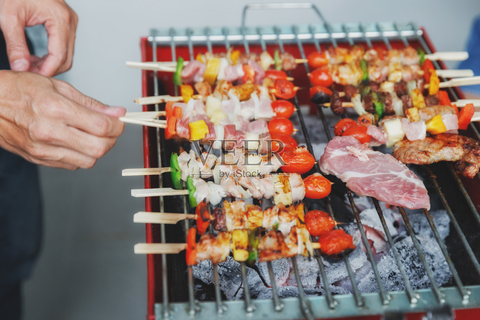 一个男人在宴会上烤猪肉和烤肉。食物，人和家庭时间的概念。照片摄影图片