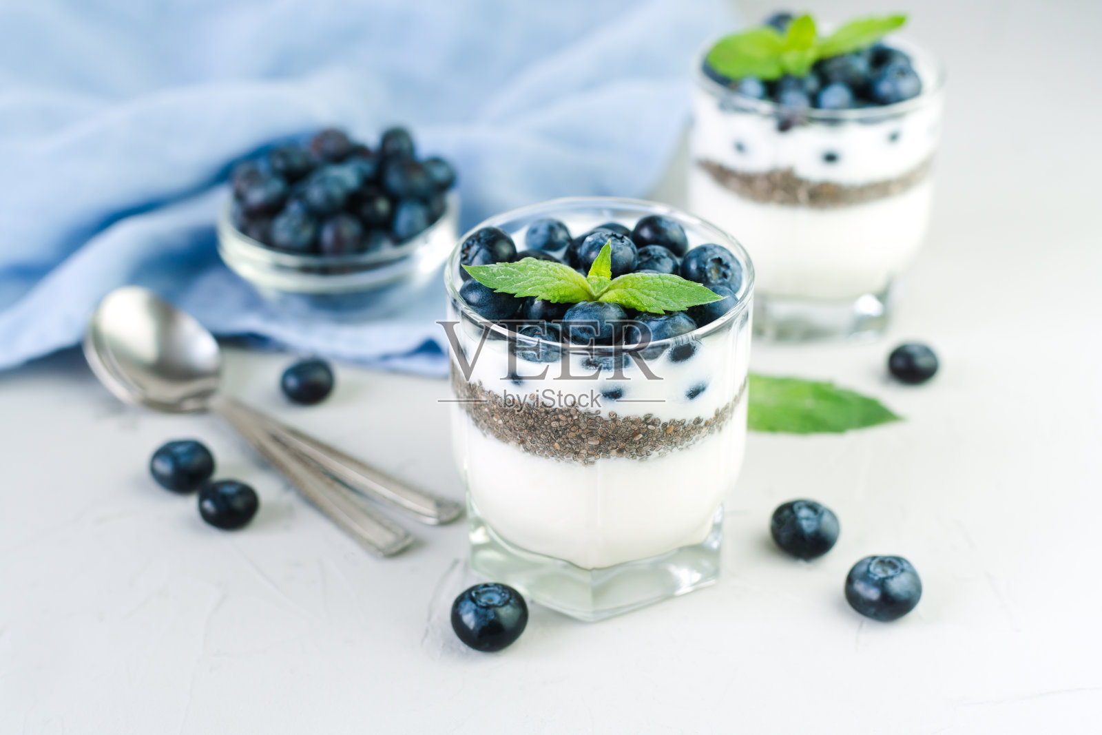 美味和健康的甜点，酸奶，奇亚籽和新鲜的蓝莓在桌子上。健康的早餐。失去。照片摄影图片