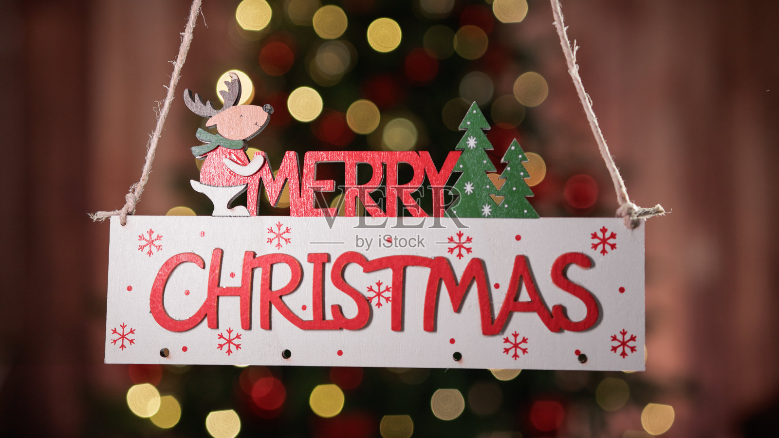 圣诞快乐的标志装饰与模糊的圣诞树照片摄影图片
