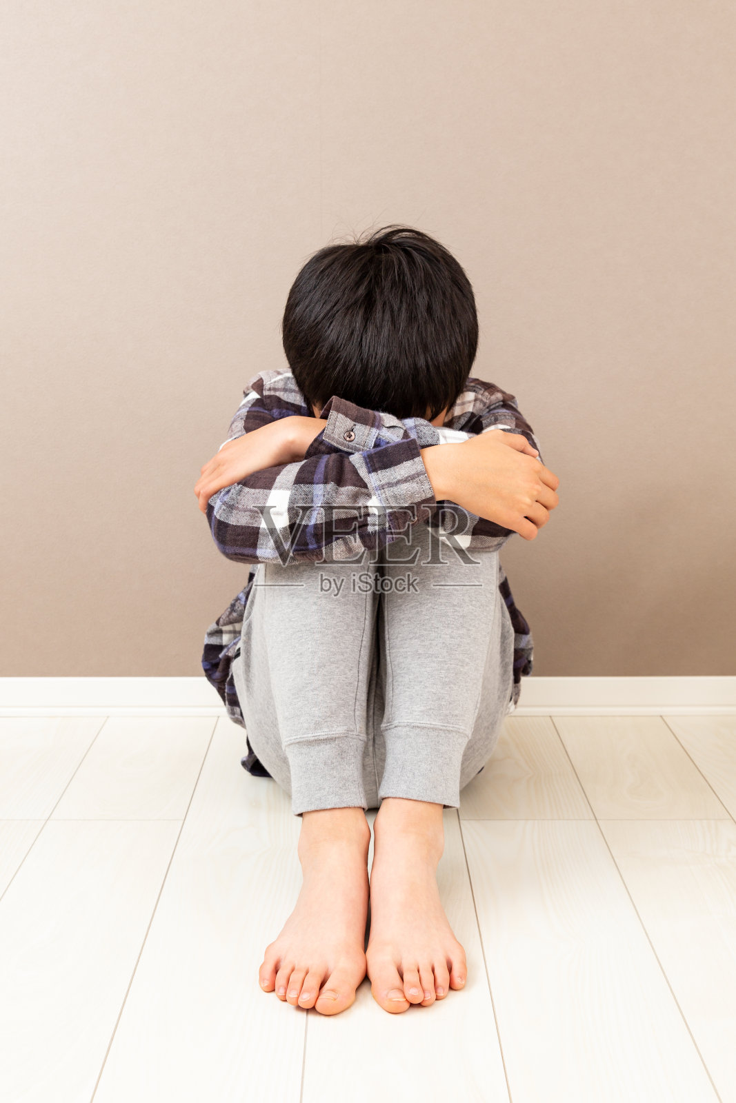 一个男孩在他的房间里感到沮丧。照片摄影图片