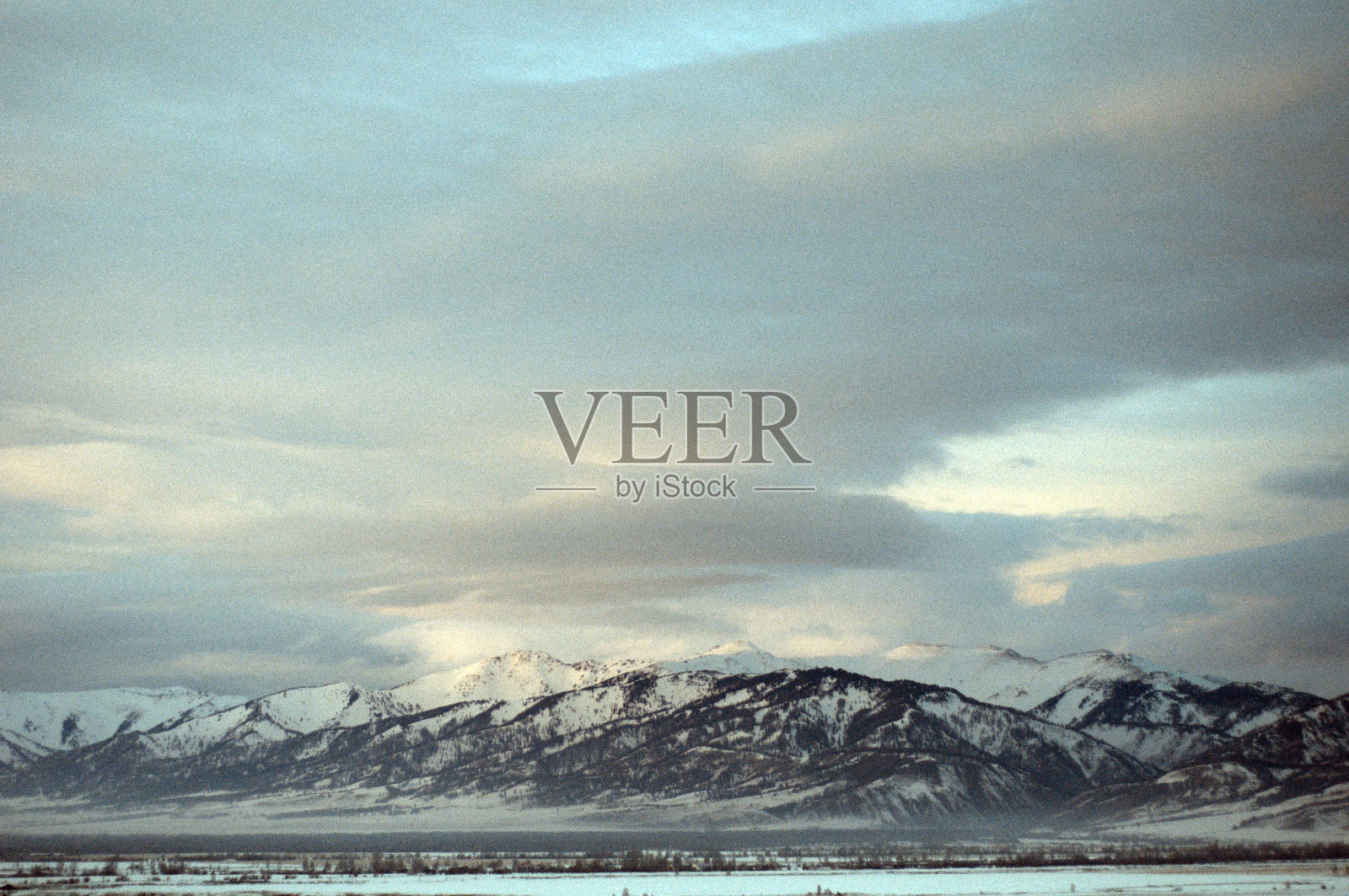 日落时寒冷的雪山景观。照片摄影图片