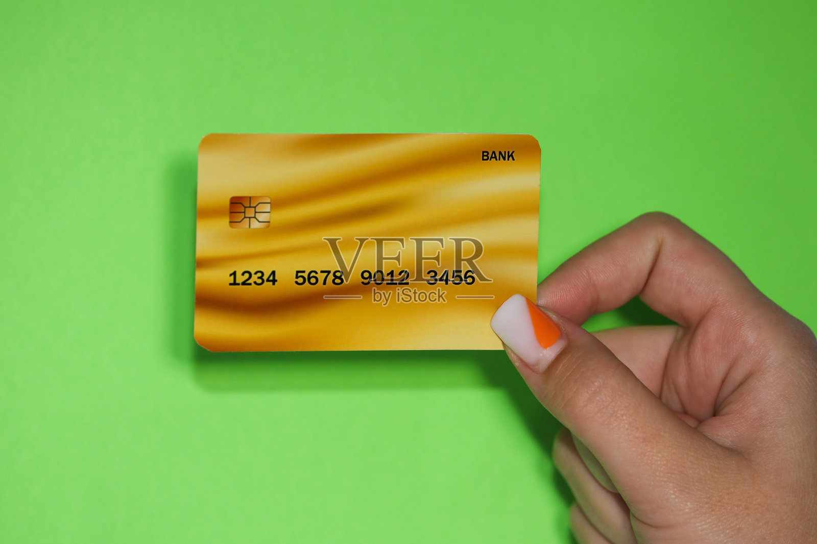 近距离女性手持悬浮模板模型银行信用卡与在线服务隔离在绿色背景照片摄影图片