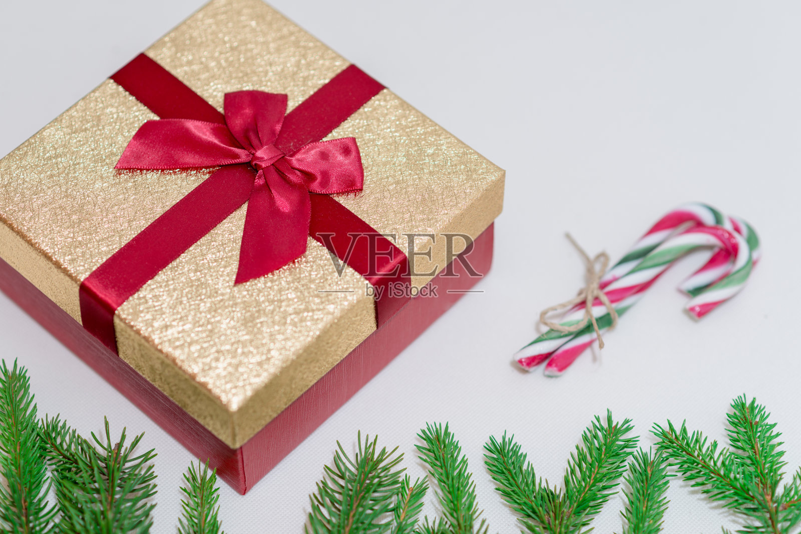 圣诞礼盒，白色背景下的树枝和棒棒糖照片摄影图片
