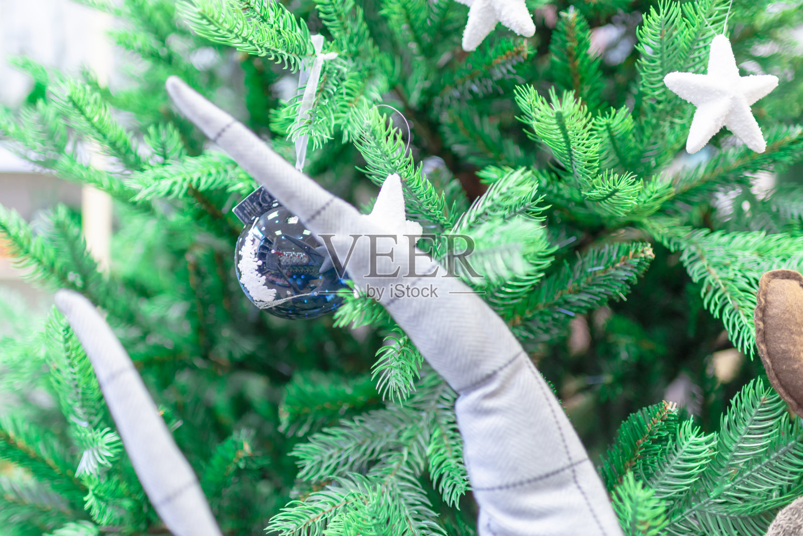 近距离的圣诞树装饰，白色的球，闪闪发光的球和雪花星。照片摄影图片