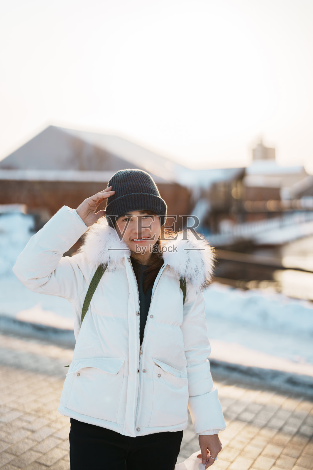 在函馆参观的女游客，穿着毛衣的游客在冬天观赏金森红砖仓库。它是日本北海道的地标和著名景点。旅游度假概念照片摄影图片