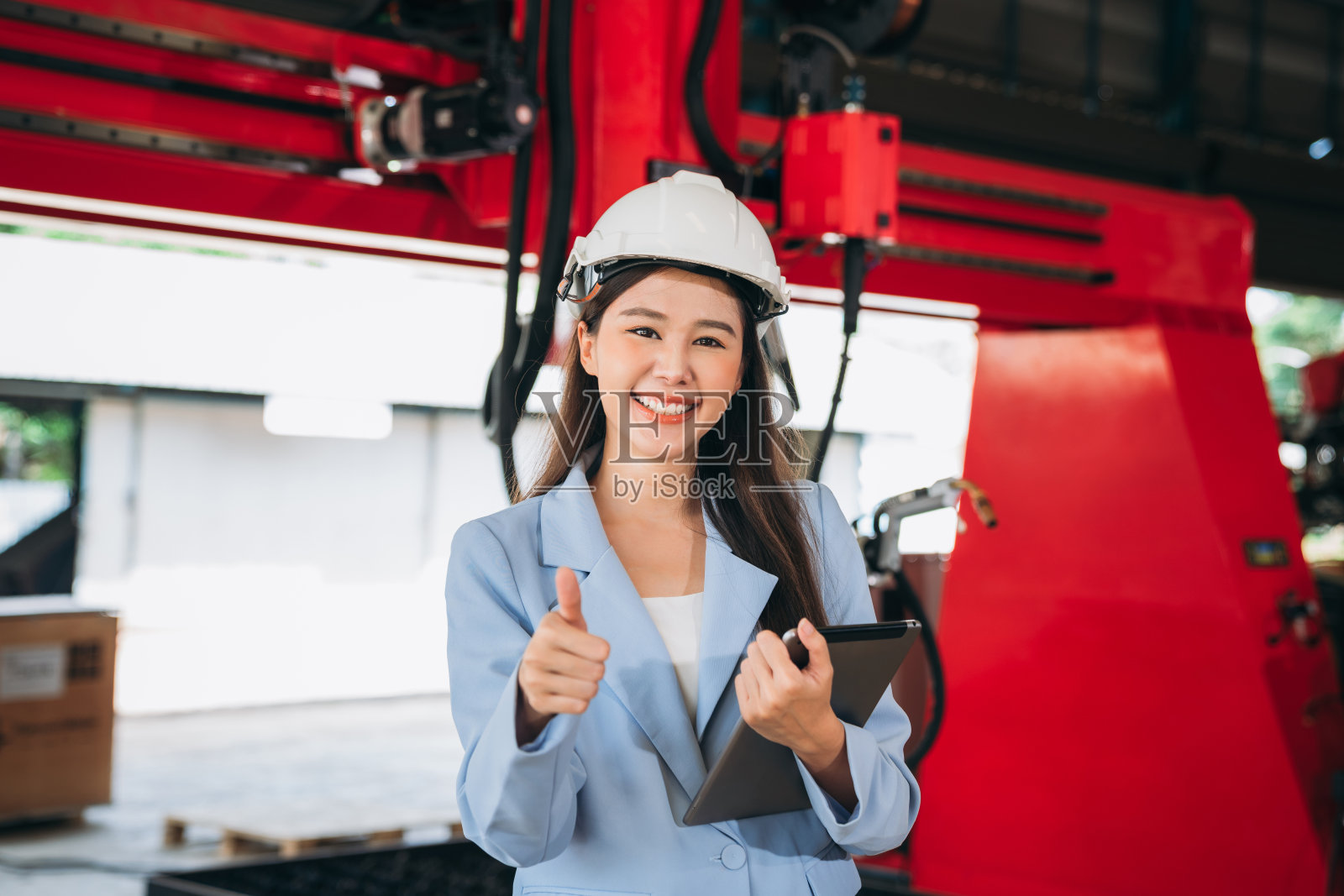 图为工程师在工厂机器上检查和检查自动臂机焊接机器人的机器。在工业生产中与药片打交道的技术员。照片摄影图片