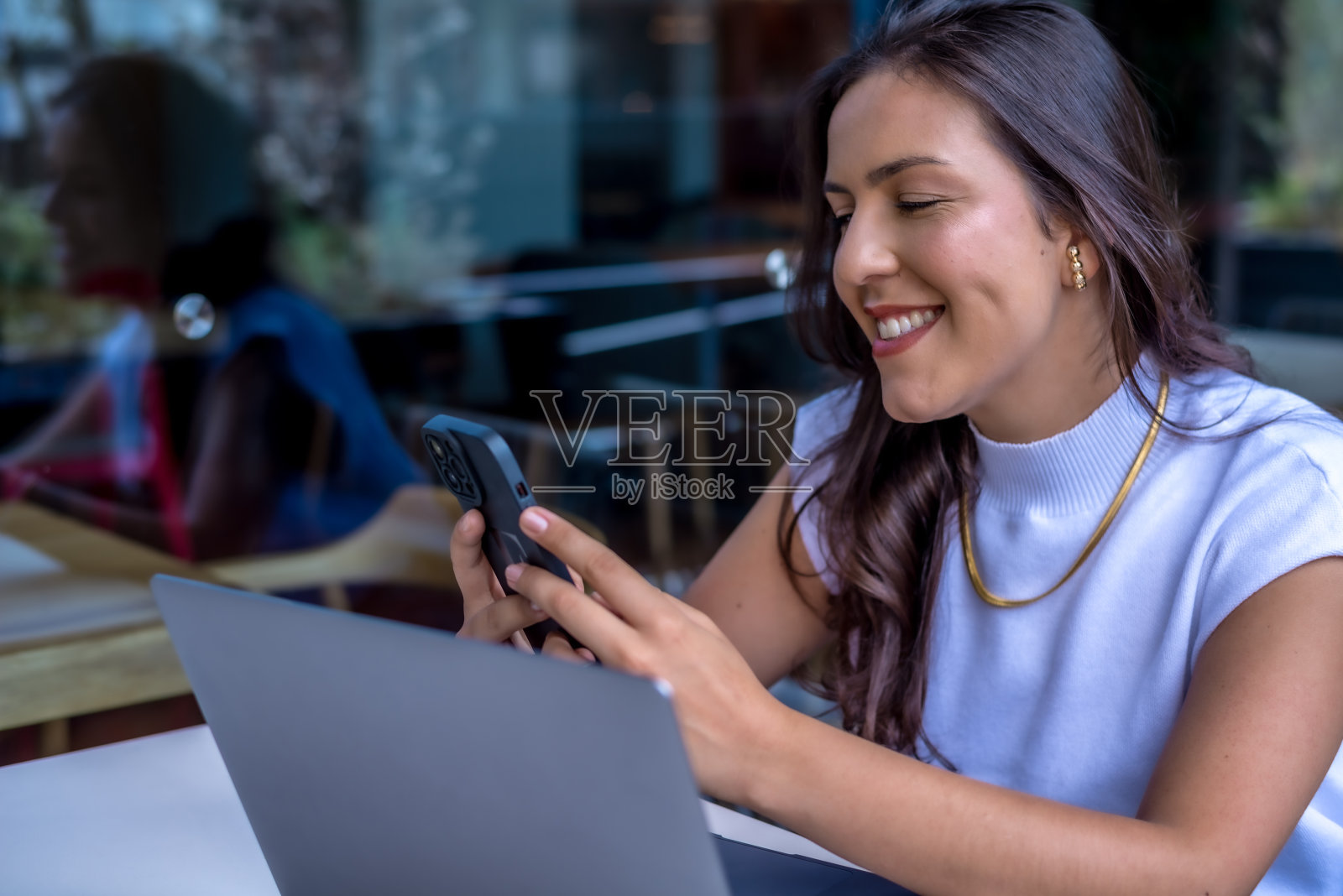 手里拿着手机微笑着照片摄影图片