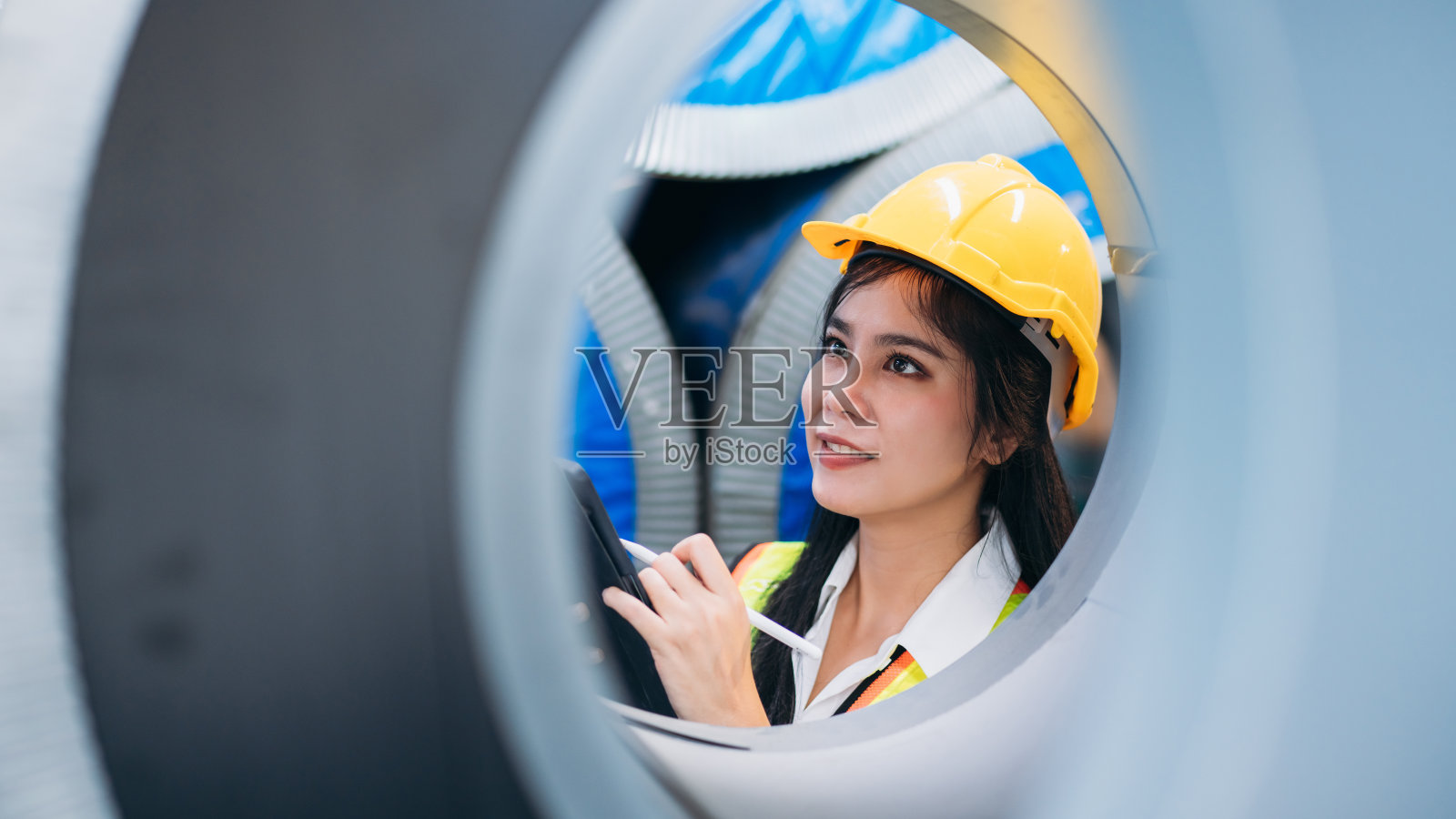 工业工人在工厂机器前用压片机检查。在钣金公司工作的技术员。照片摄影图片