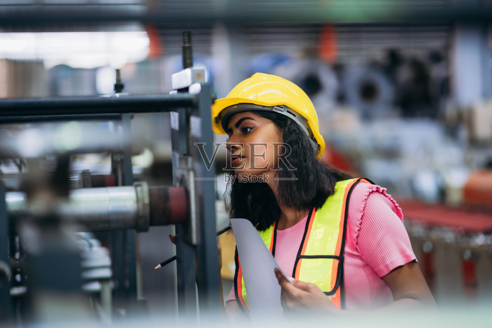 在工厂机器前检查机器的工人。在钣金公司工作的技术员。领班检查材料或机器。照片摄影图片