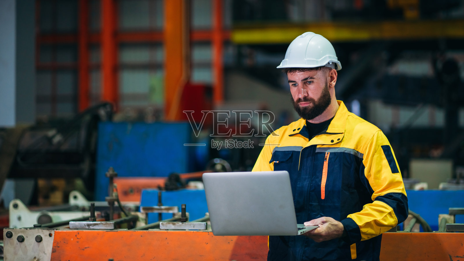 工业工人在工厂机器前用手提电脑检查。在钣金公司工作的技术员。照片摄影图片