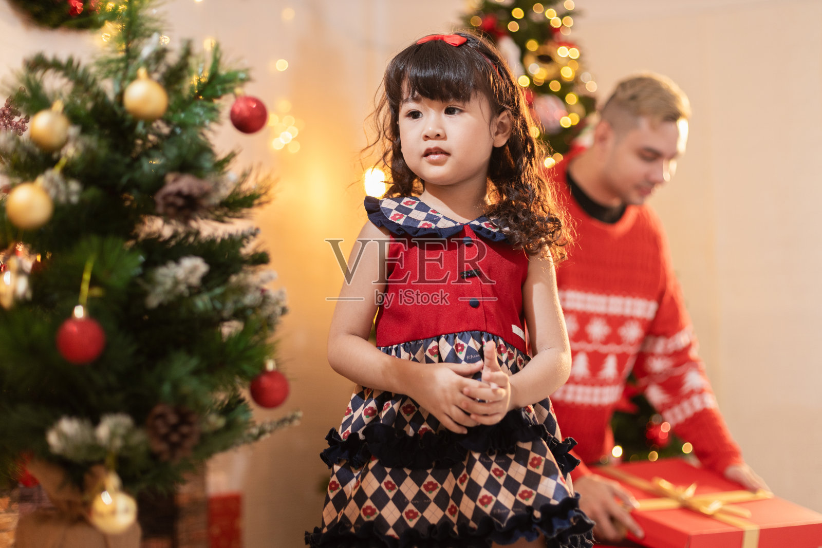 家里有圣诞树的可爱小女孩。圣诞节概念。童女庆夜。照片摄影图片