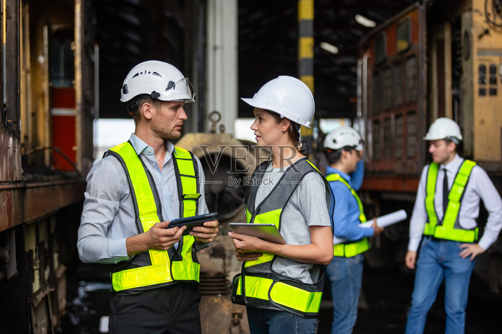班组铁路技术工程师在维修中心检查维修服务项目列车柴油机。技术人员讨论项目计划，检查车辆和铁路系统。照片摄影图片