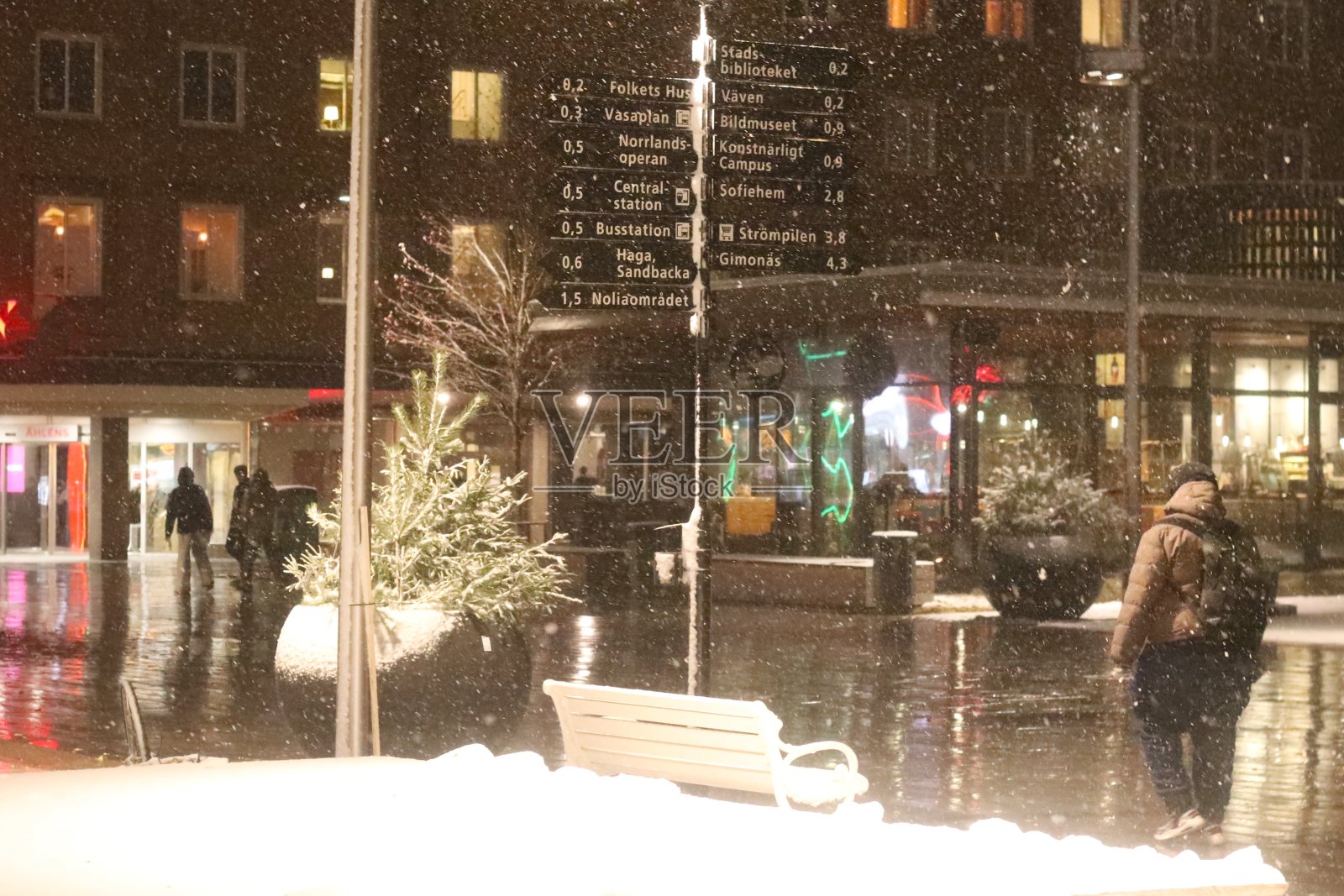 黑暗的城市里有路灯。尤梅夫市潮湿和下雪的街道。在瑞典北部寒冷的十一月，五彩缤纷的街道。照片摄影图片