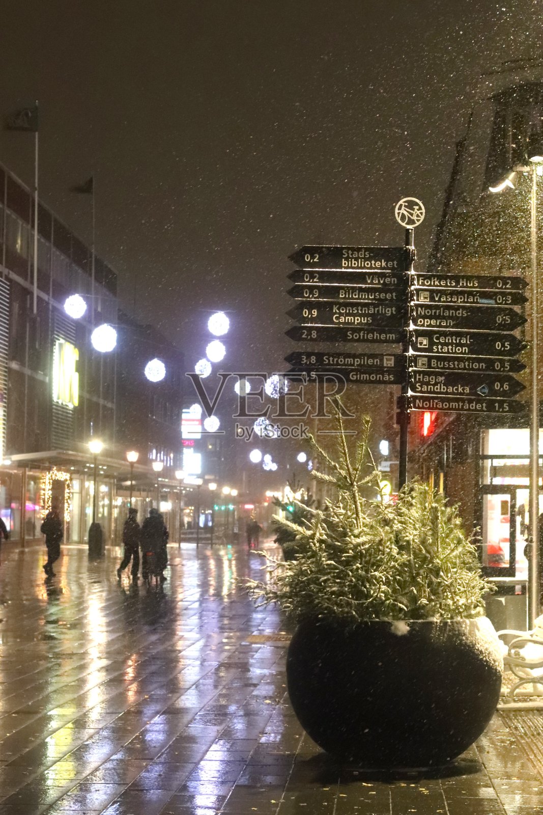 黑暗的城市里有路灯。尤梅夫市潮湿和下雪的街道。在瑞典北部寒冷的十一月，五彩缤纷的街道。照片摄影图片