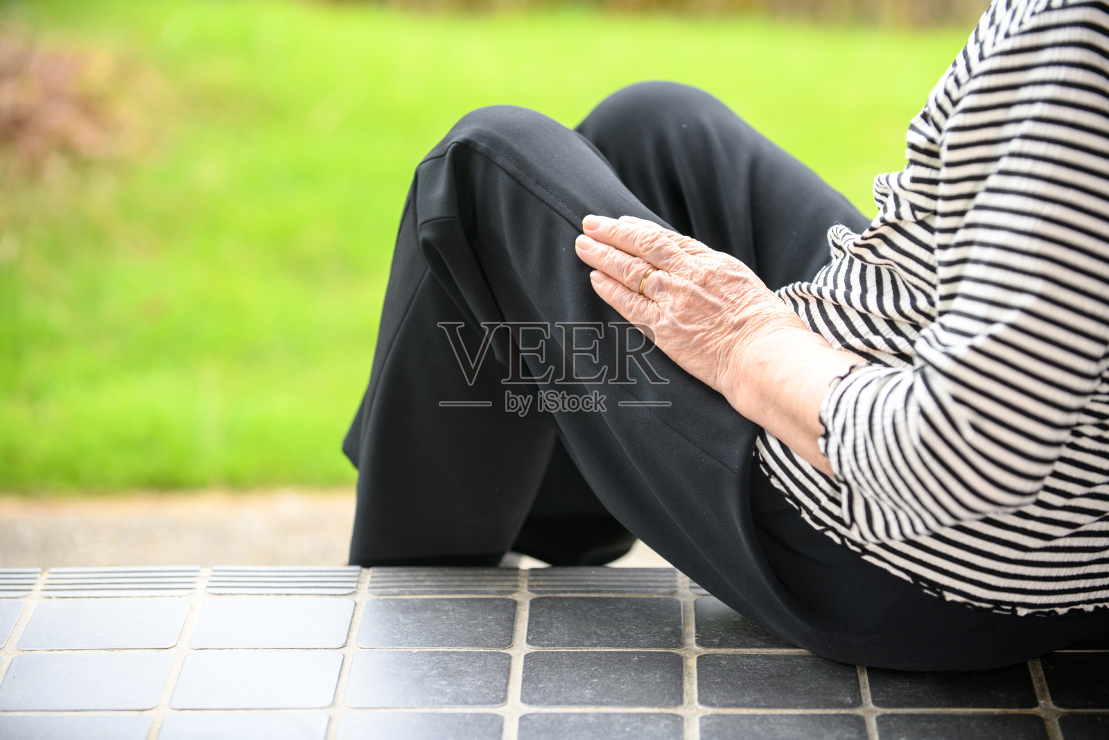 老年妇女坐在入口台阶上照片摄影图片