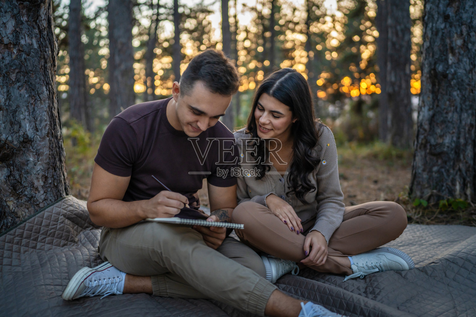 男人和女人，年轻的成年夫妇在大自然中抱着，画着照片摄影图片