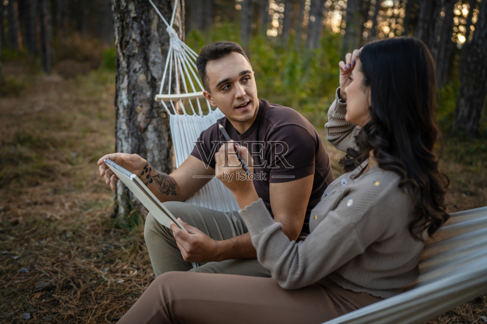 男人和女人，年轻的成年夫妇在大自然中抱着，画着照片摄影图片