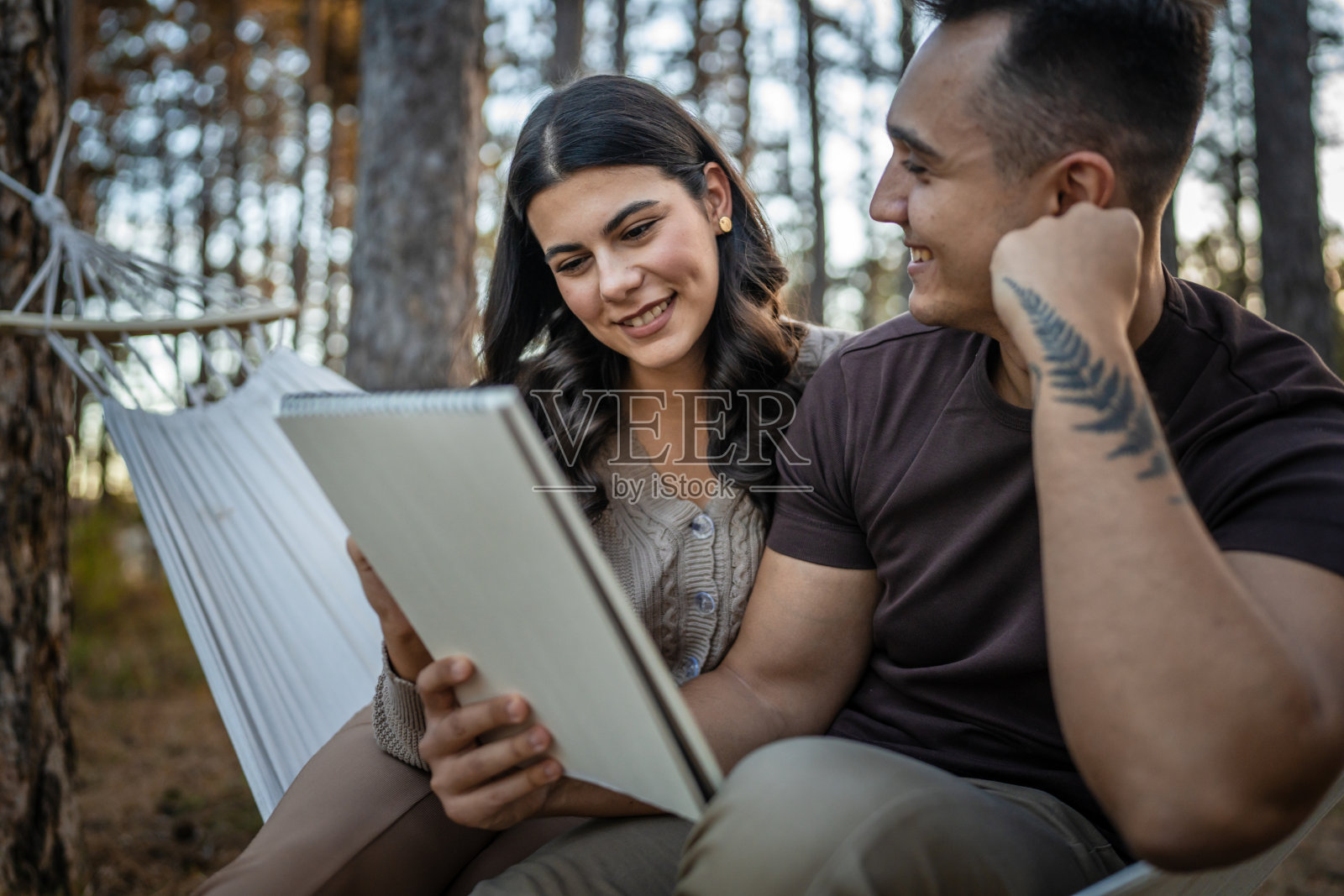 男人和女人，年轻的成年夫妇在大自然中抱着，画着照片摄影图片