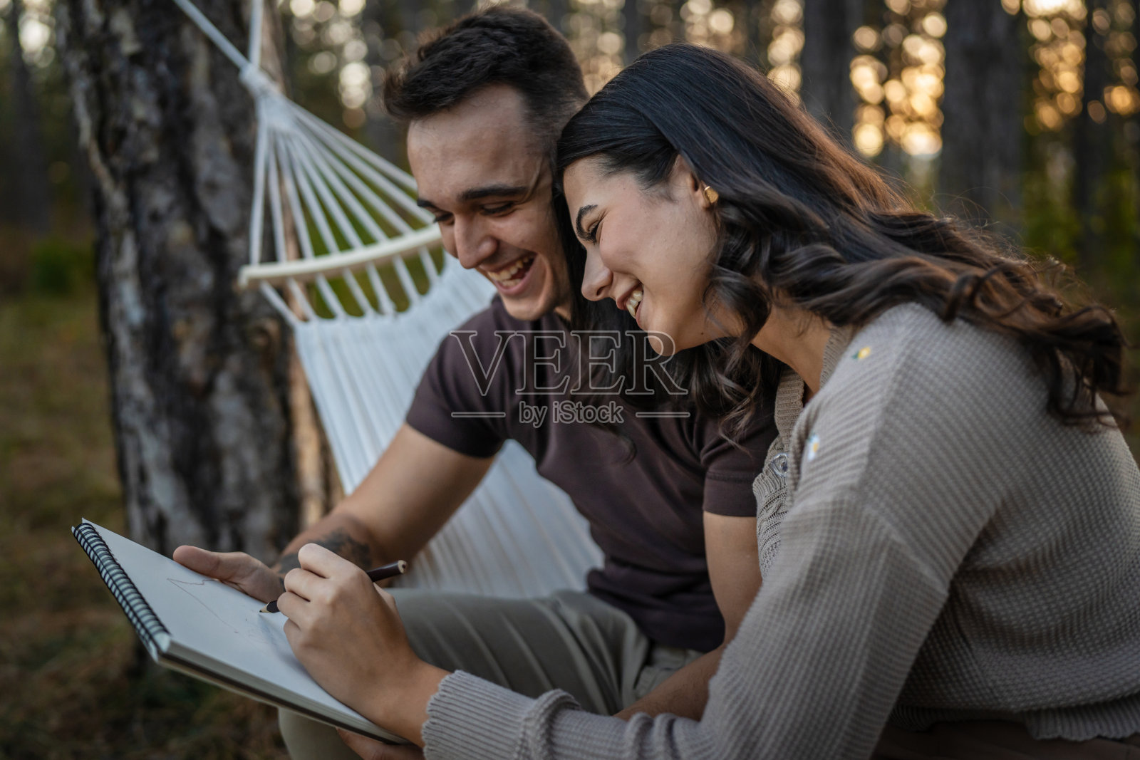 男人和女人，年轻的成年夫妇在大自然中抱着，画着照片摄影图片