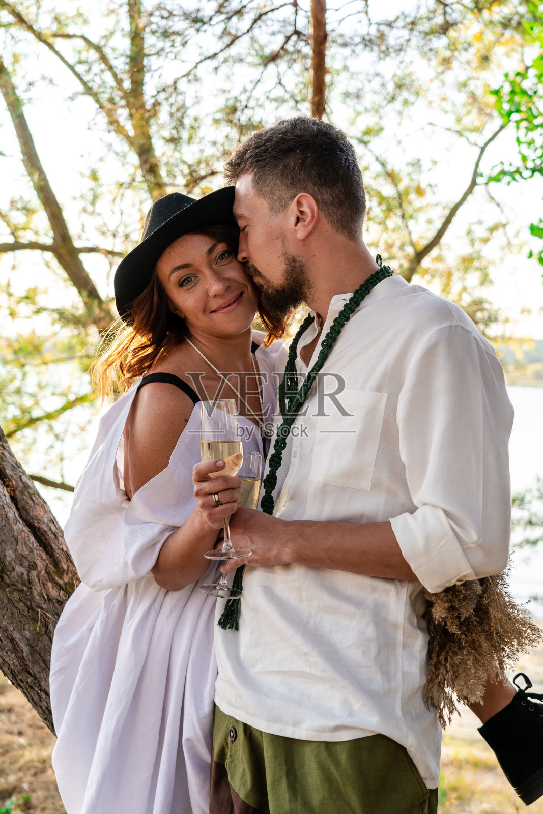 美丽的婚礼新娘和新郎在大自然的香槟杯照片摄影图片