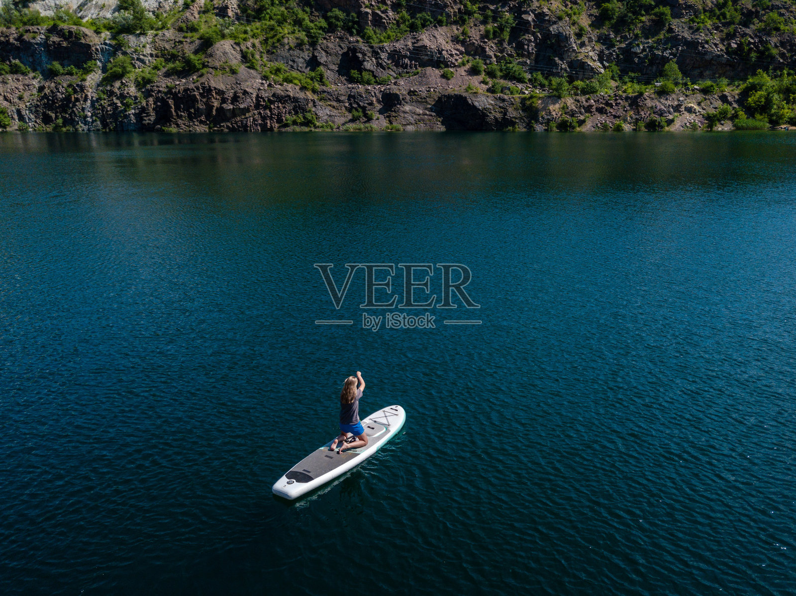 鸟瞰图上的女子在桨板上的湖照片摄影图片