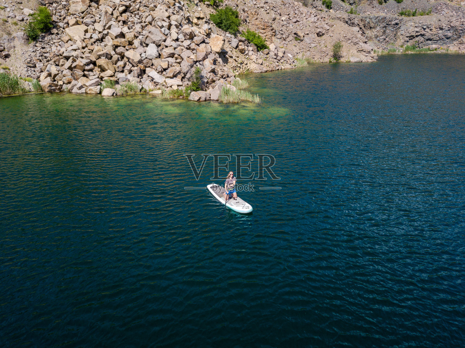鸟瞰图上的女子在桨板上的湖照片摄影图片