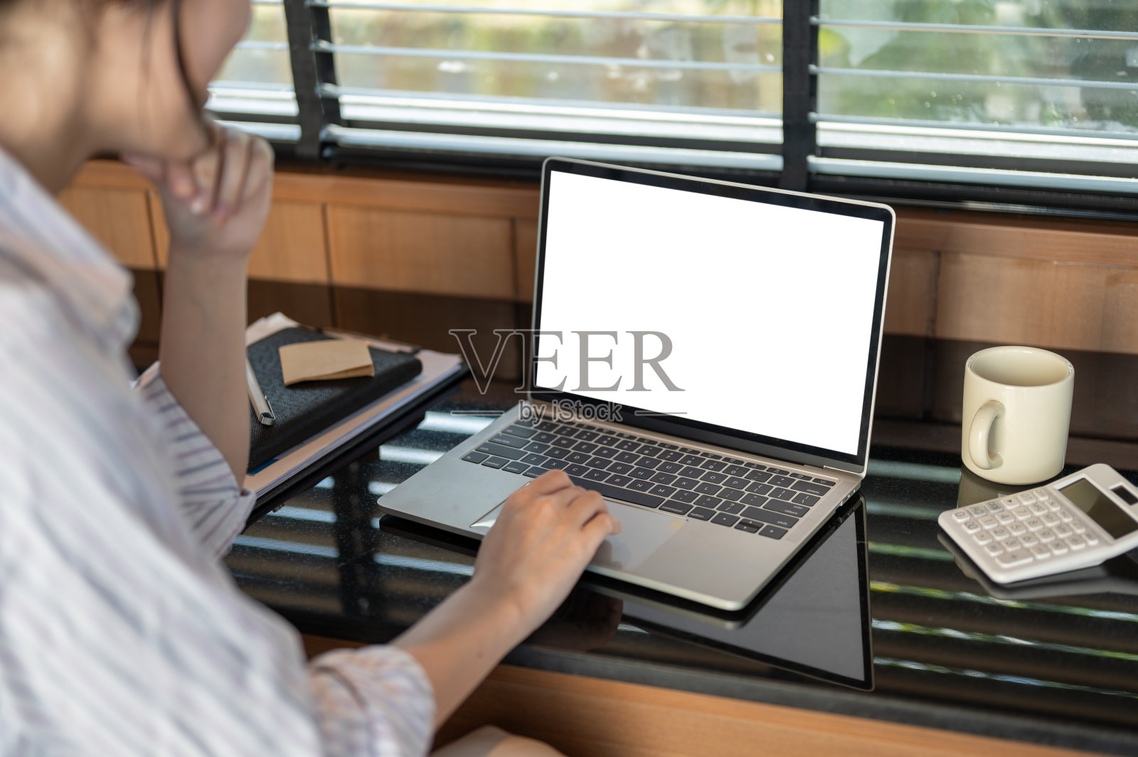 一个女商人在室内用笔记本电脑工作，思考和计划她的工作。照片摄影图片