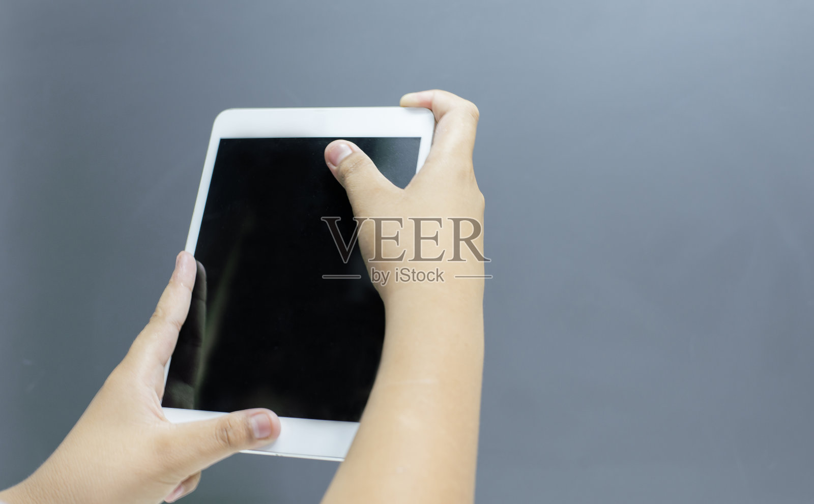 灰色背景上的手势和ipad照片摄影图片
