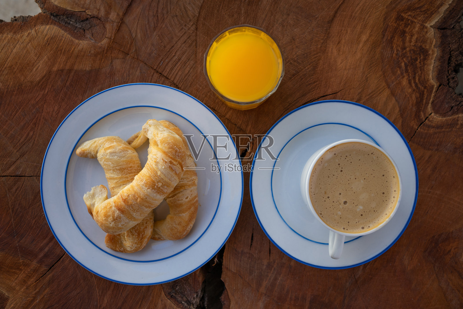 早餐俯视图:咖啡配牛角面包和橙汁。木制背景照片摄影图片