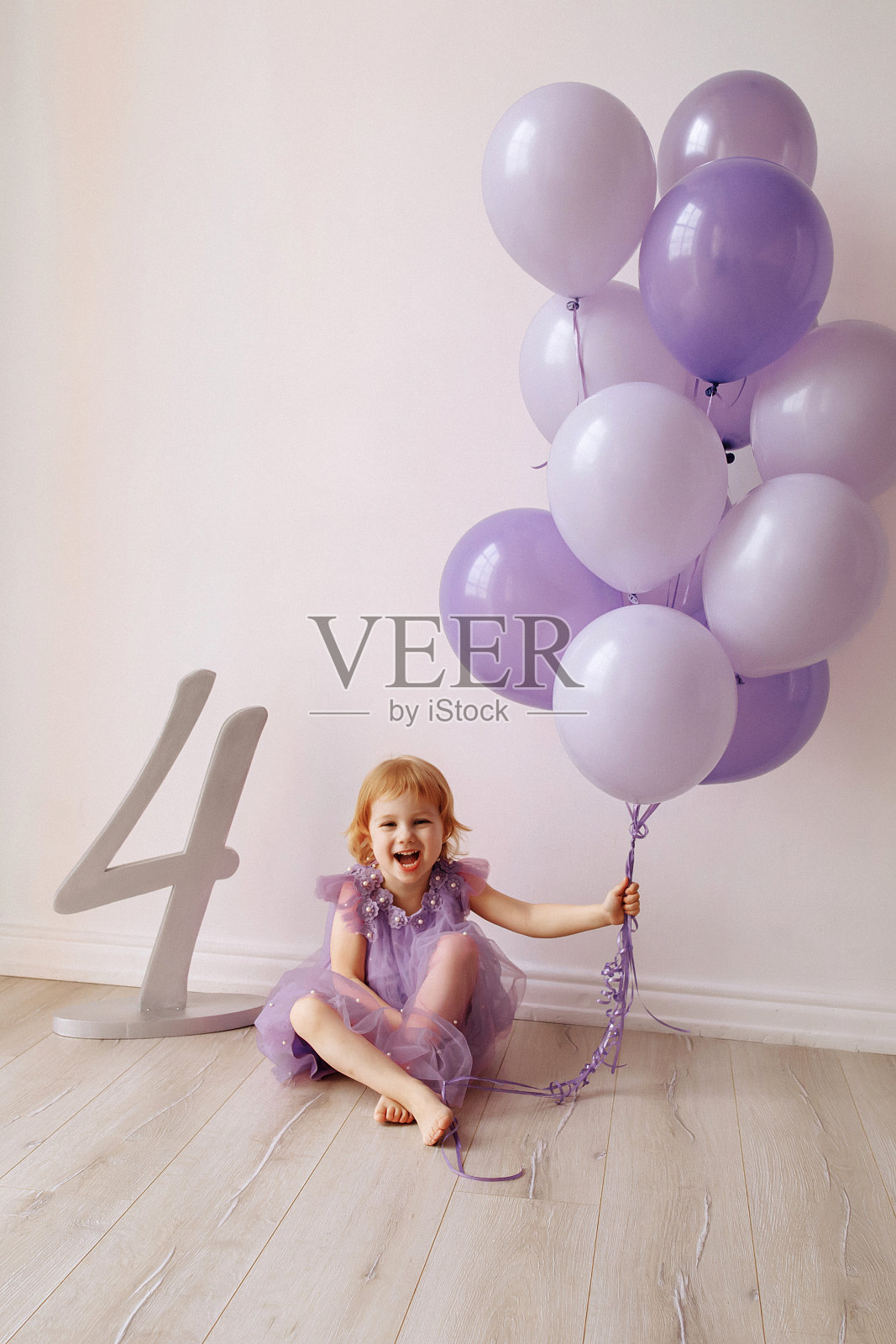 4岁的小女孩，穿着带白色气球的裙子照片摄影图片