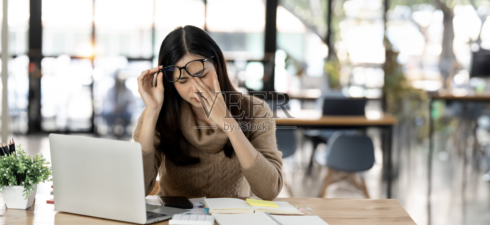 年轻女性在笔记本电脑上工作时压力很大，在办公室头痛的疲惫的女商人，在工作时感到恶心，复印空间照片摄影图片