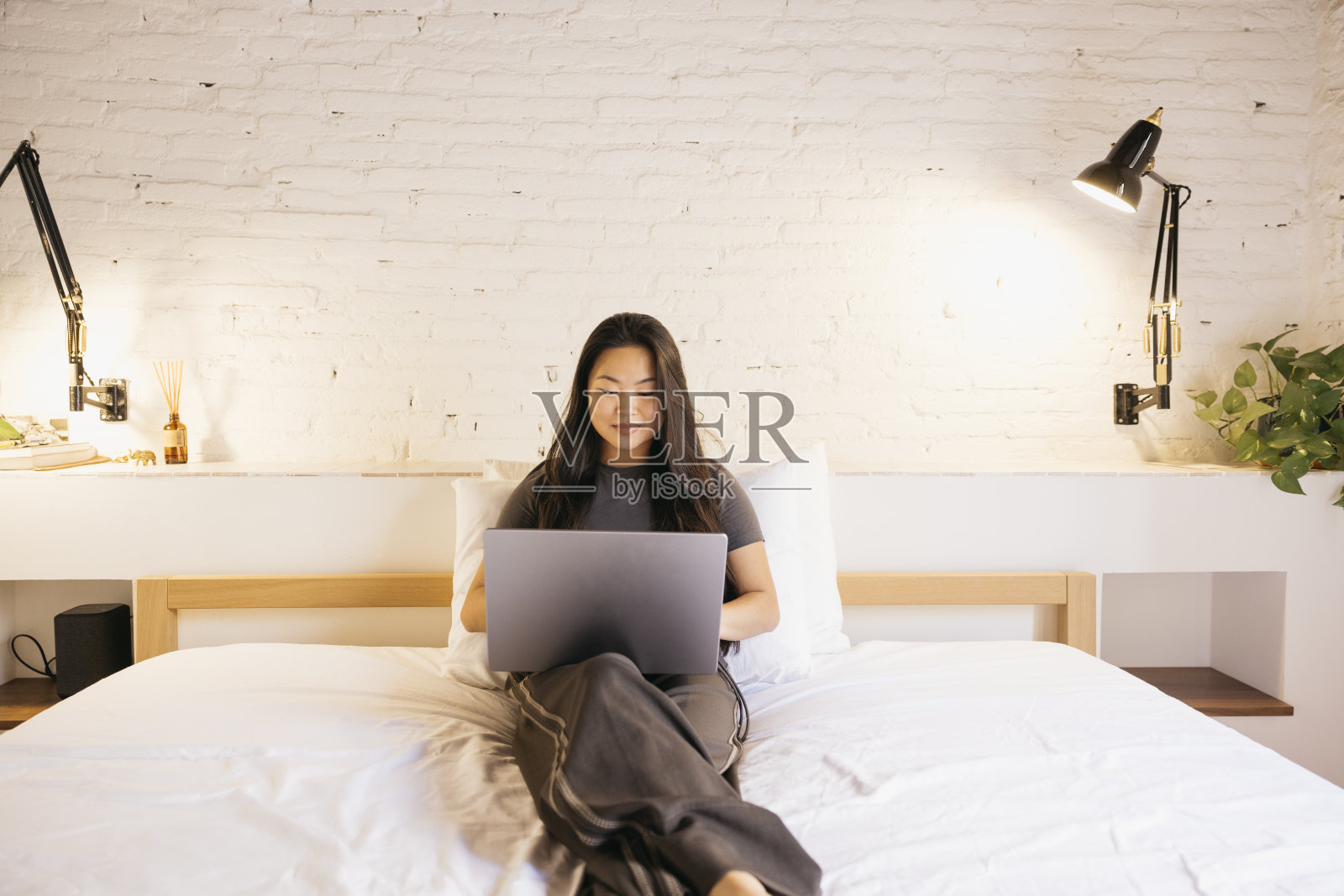 年轻女子在床上用笔记本电脑照片摄影图片