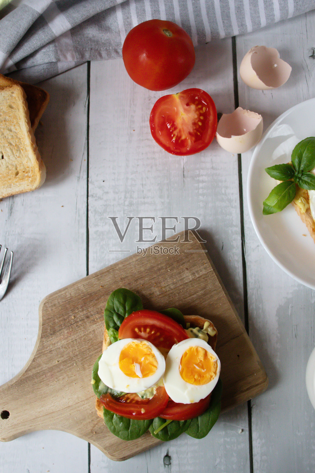 健康早餐，有鸡蛋、西红柿和沙拉。在一张木桌上。食物照片摄影图片