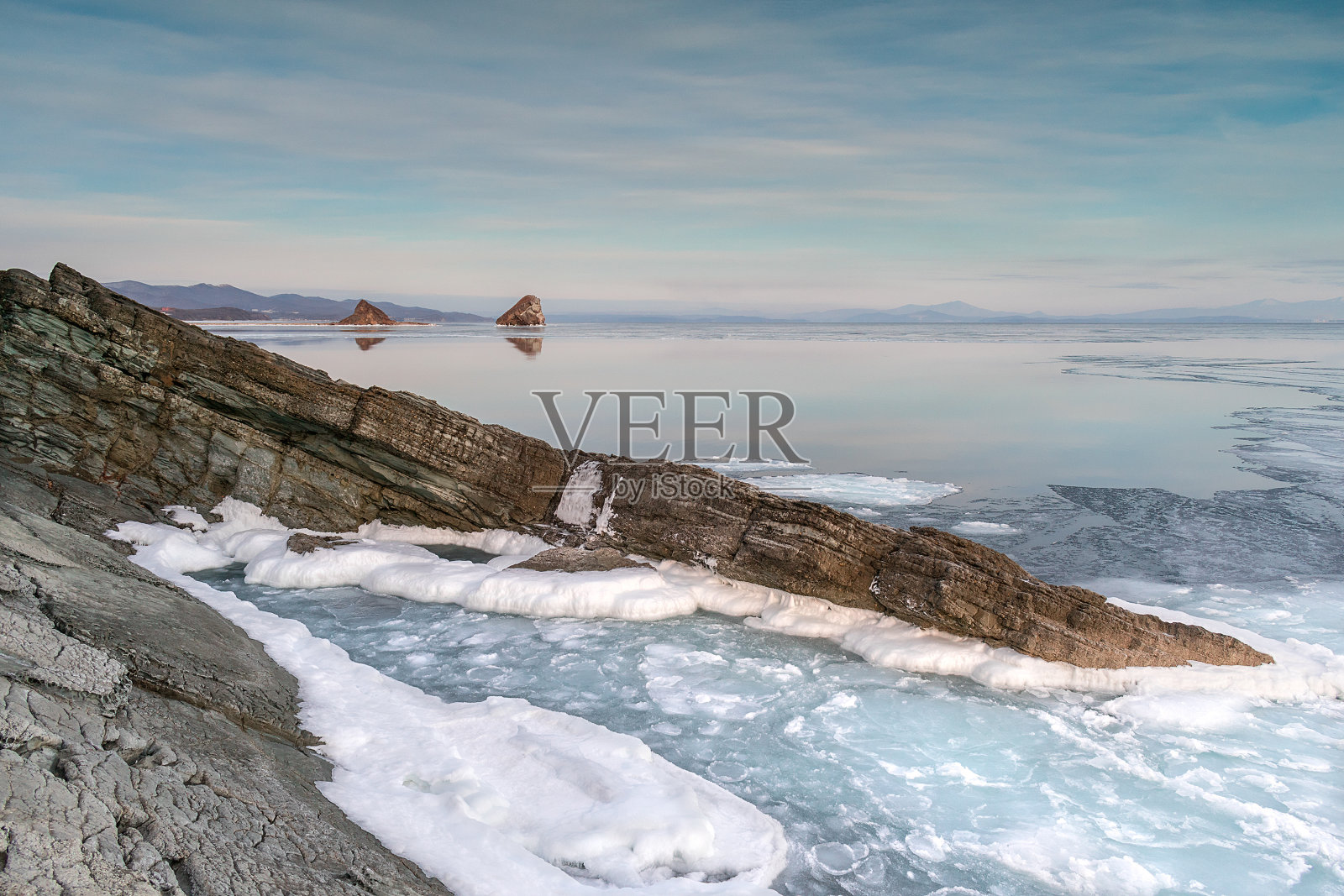 冬季日落时海面上的海泥和浮冰。照片摄影图片