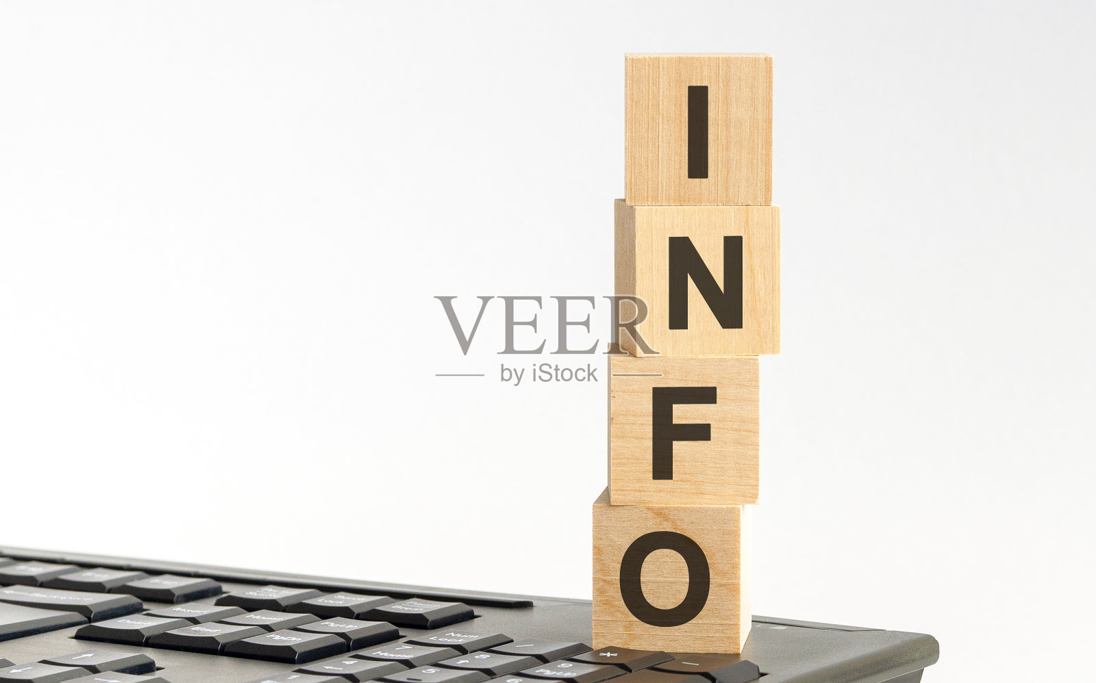 单词INFO与木块在键盘上，浅白色的背景照片摄影图片