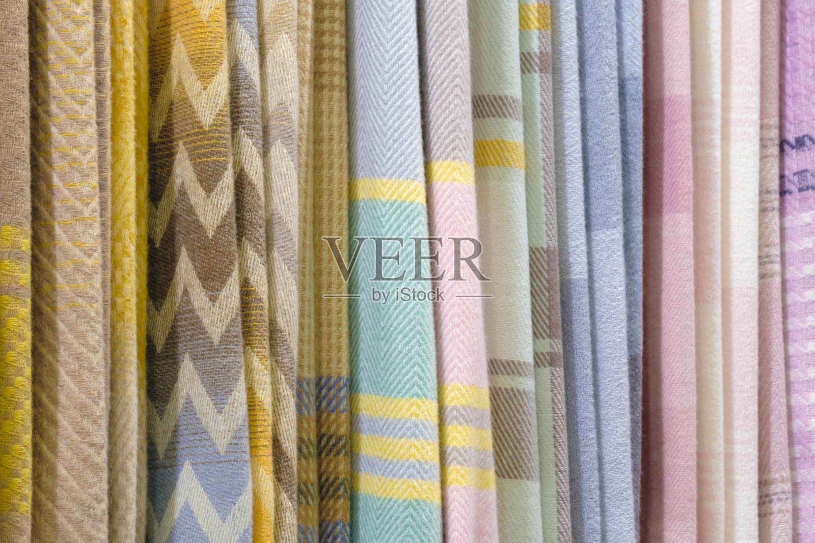 混色垂纹纺织品、面料、衣架上的布匹。近距离观察彩色织物的纹理。照片摄影图片