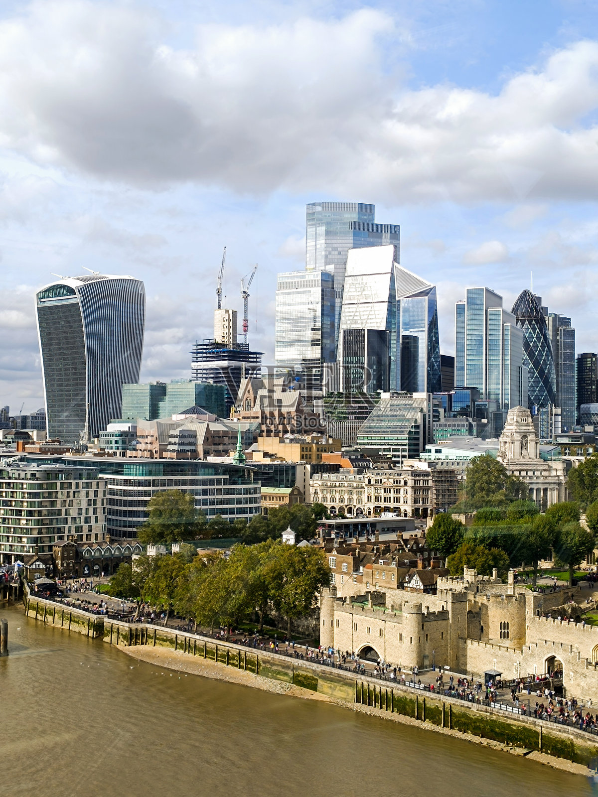 在伦敦泰晤士河上，可以看到历史悠久的伦敦塔和这座城市的现代摩天大楼照片摄影图片