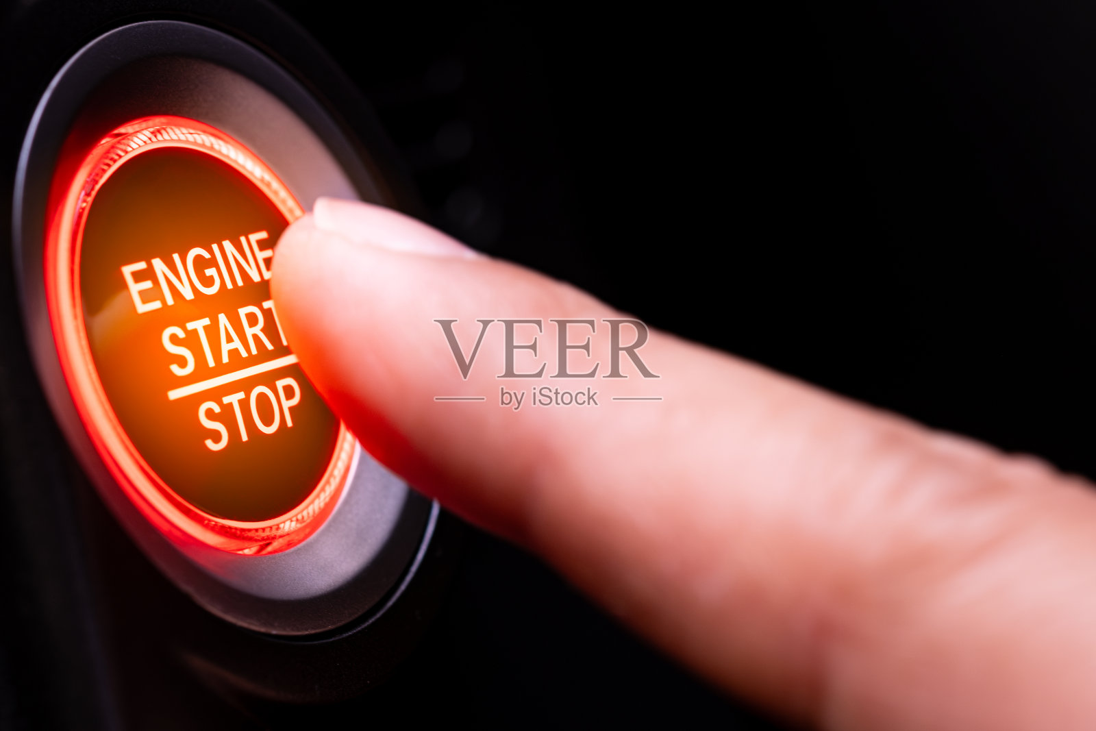 驾驶员的手正在按汽车启动按钮。交通和技术的概念照片摄影图片