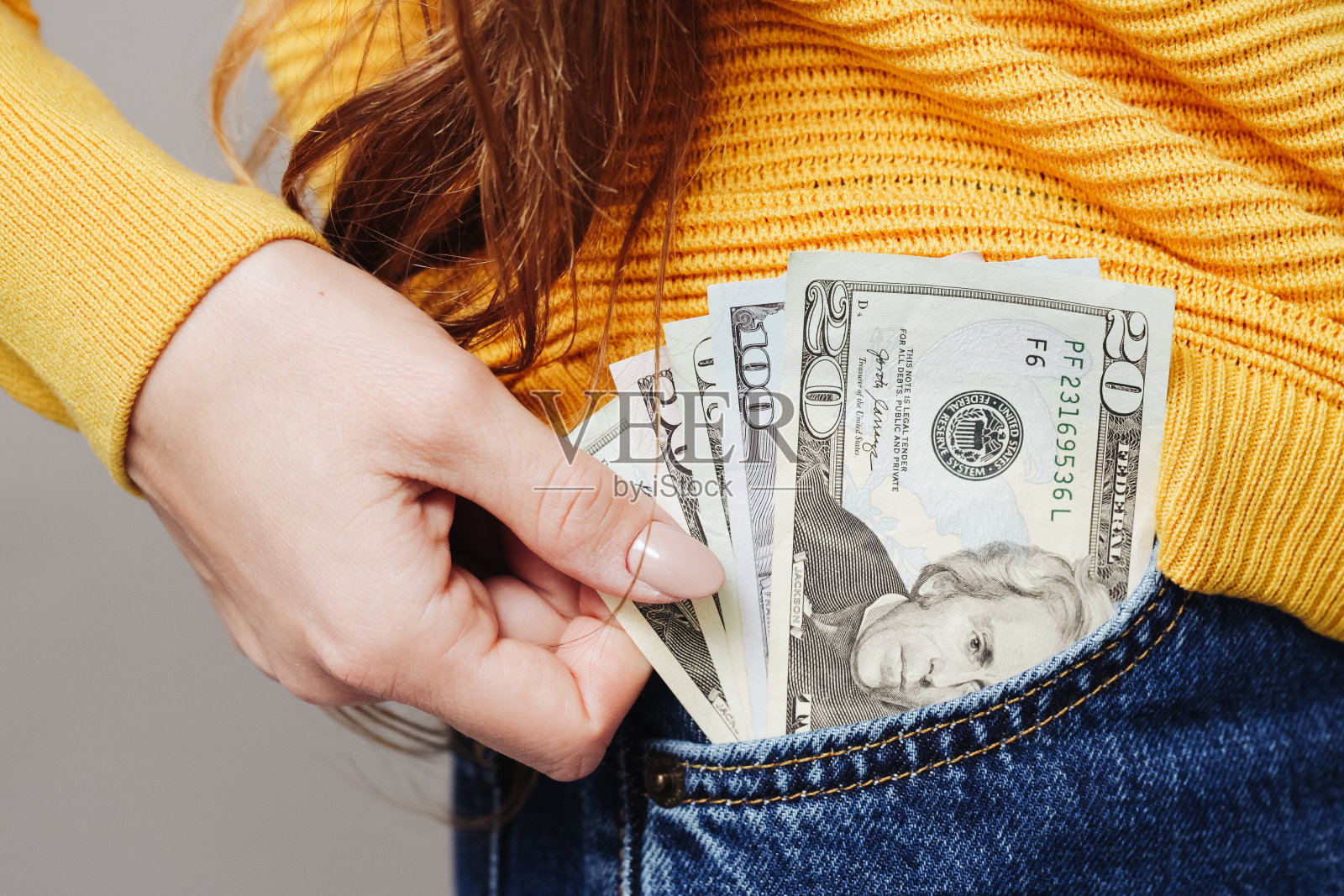 零用钱背景。前口袋里有美元钞票。穿蓝色牛仔裤的女人。穿裤子的性感女孩。穿牛仔裤的女人。照片摄影图片