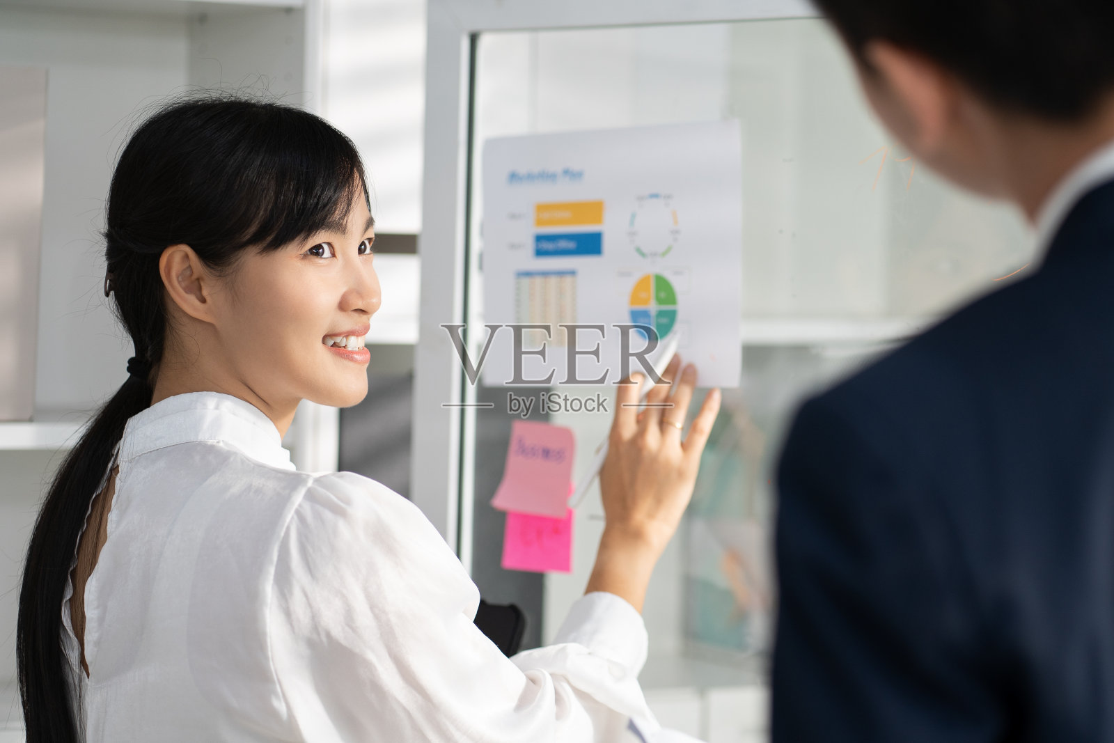 作为产品开发过程的一部分，专业女性领导对项目流程图的讨论。一位女商人在办公室的团队会议上解释她战略的每一步。照片摄影图片