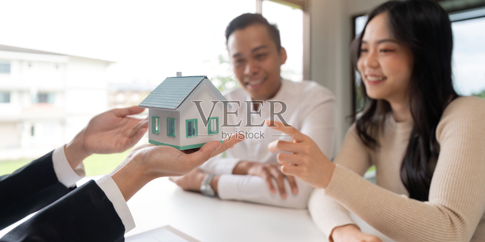 年轻的已婚夫妇坐在桌子旁，听房地产经纪人、房地产经纪人、贷款经纪人或抵押贷款顾问讲述各种选择照片摄影图片