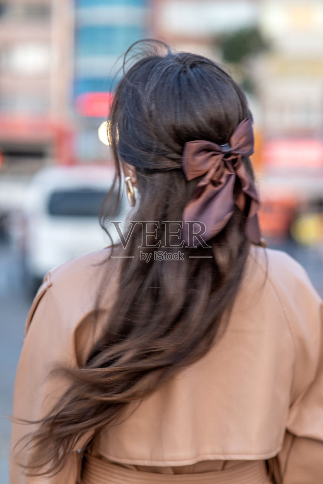 从走在城市里的女人身后可以看到缎带照片摄影图片